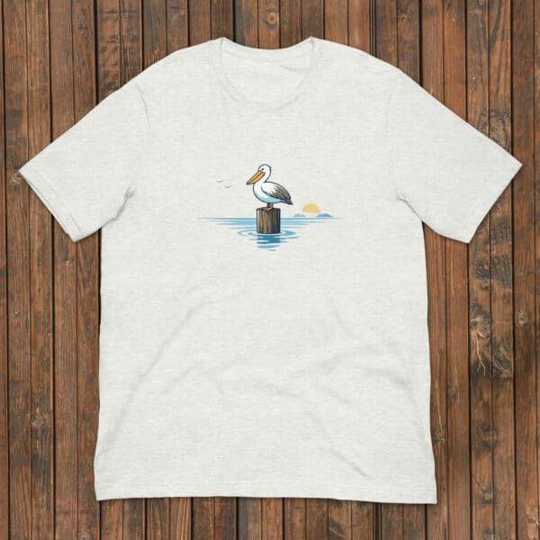 A graphic of a pelican standing on a wooden log at sunset, calm water, and flying birds, ideal for birdwear clothing collections.