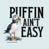 Illustration of a puffin holding a fish with text Puffin Ain't Easy.